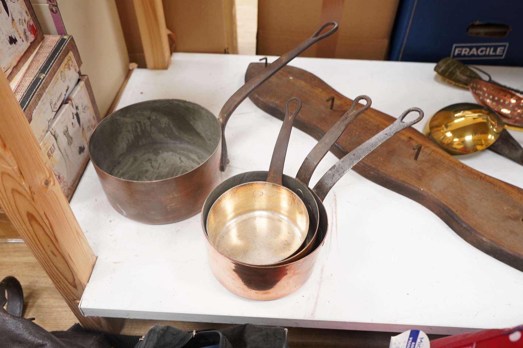 A graduated set of 4 saucepans and a hanging rack- 70 cm wide